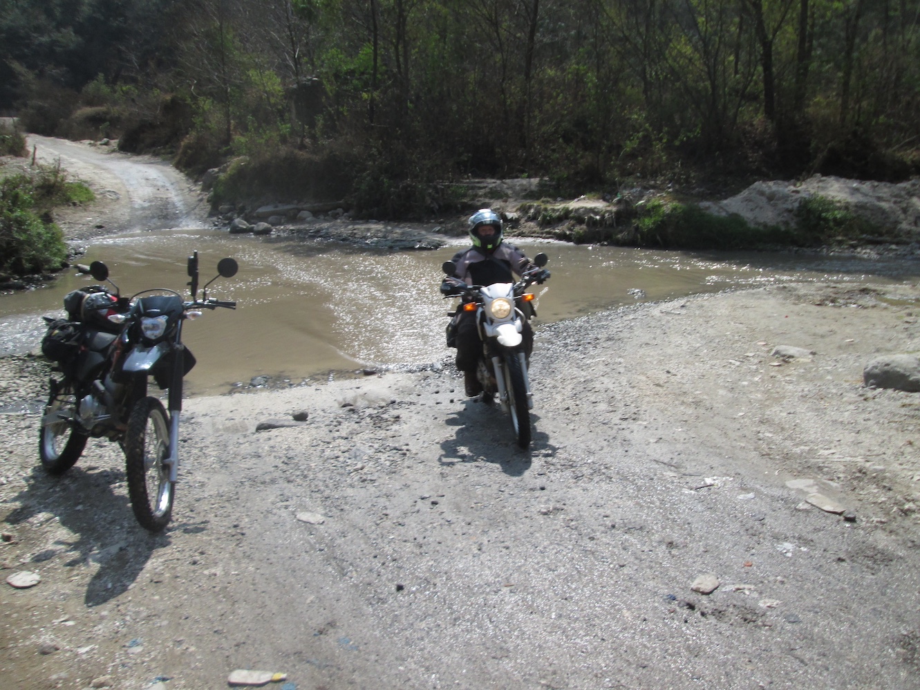 motorcycle
            begins crossing a river in shallow water