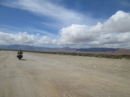 motorcycle and rider out on a white sand landscape